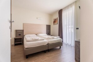 A bedroom with a bed, bedside tables, and a window with curtains. - Residence Maroadi (Nago-Torbole)