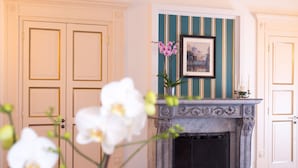 A room with a fireplace, a framed picture above it, and a door with a decorative panel. - B&B Maiurè (Maiori)