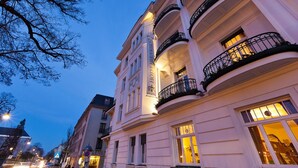 Un edificio histórico con varios balcones, ventanas amplias y detalles arquitectónicos clásicos.