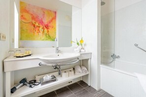 Een bad/douchecombinatie, een diep bad, gratis toiletartikelen