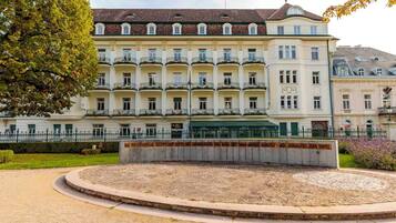 A multi-story hotel with a symmetrical facade, balconies, and a central courtyard.