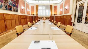 Ein Konferenzraum mit langem Tisch, Stühlen und einer dekorativen Wand.