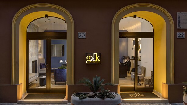 A hotel entrance with two arched doorways, numbered 20 and 22, leading into a well-lit interior with seating and a reception desk. - GKK Exclusive Private Suite (Rome)