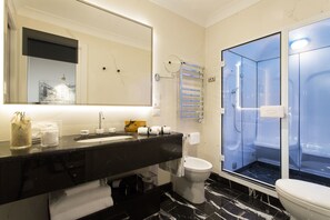 A modern bathroom with a black marble sink, a large mirror, a toilet, and a glass-enclosed shower. - GKK Exclusive Private Suite (Rome)