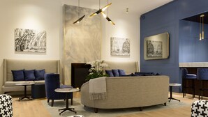 A modern lounge area with a sofa, armchairs, a coffee table, and artwork on the walls. - GKK Exclusive Private Suite (Rome)