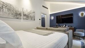 A modern hotel room with a large bed, a desk with a flat-screen TV, and two wall-mounted artworks. - GKK Exclusive Private Suite (Rome)