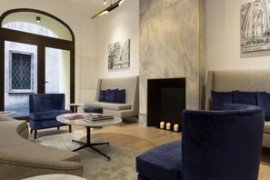 A modern living room with a sofa, armchairs, a coffee table, and a fireplace. - GKK Exclusive Private Suite (Rome)
