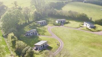 A rural property with four detached houses, a winding road, and surrounding greenery.