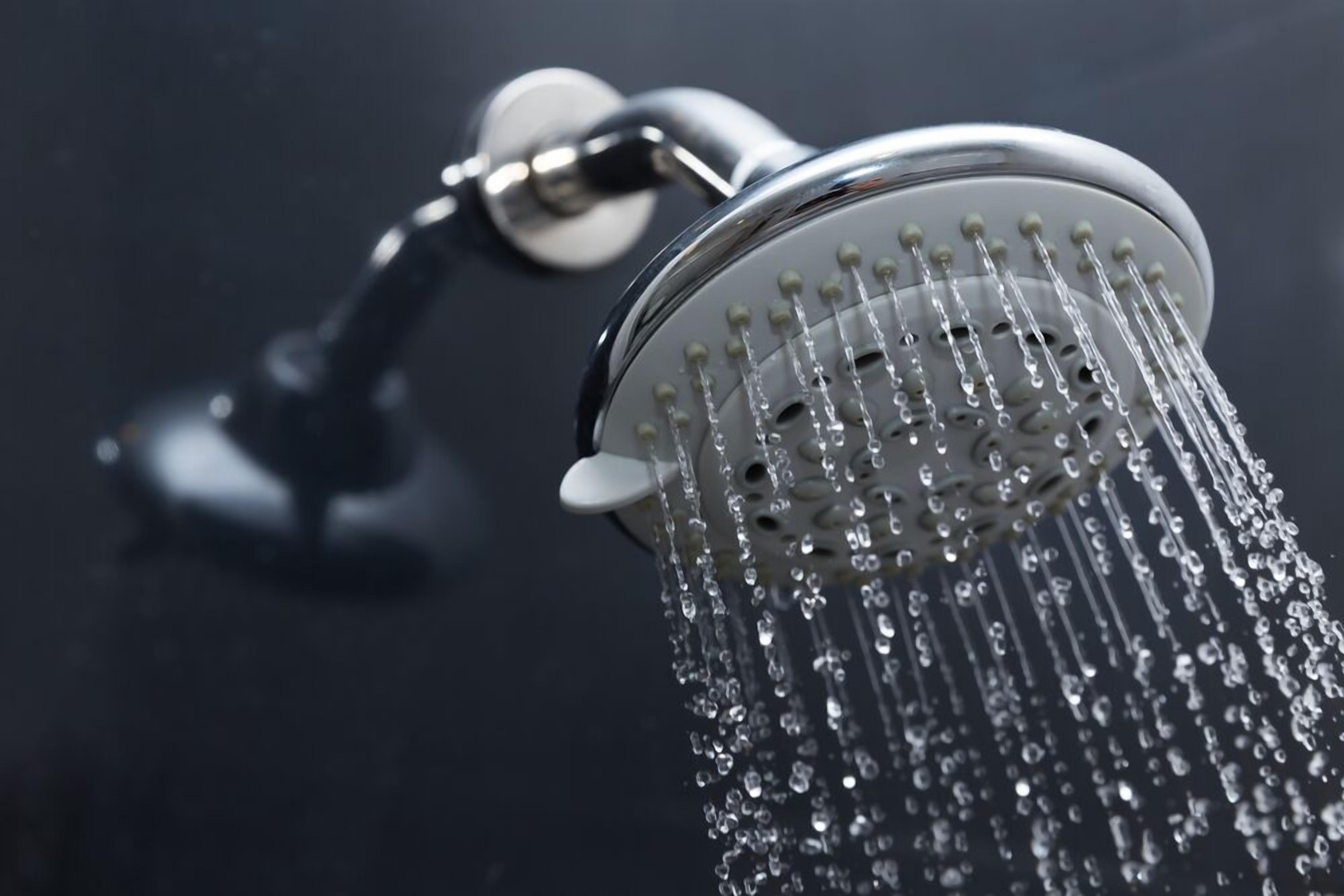 A showerhead with water flowing from it.