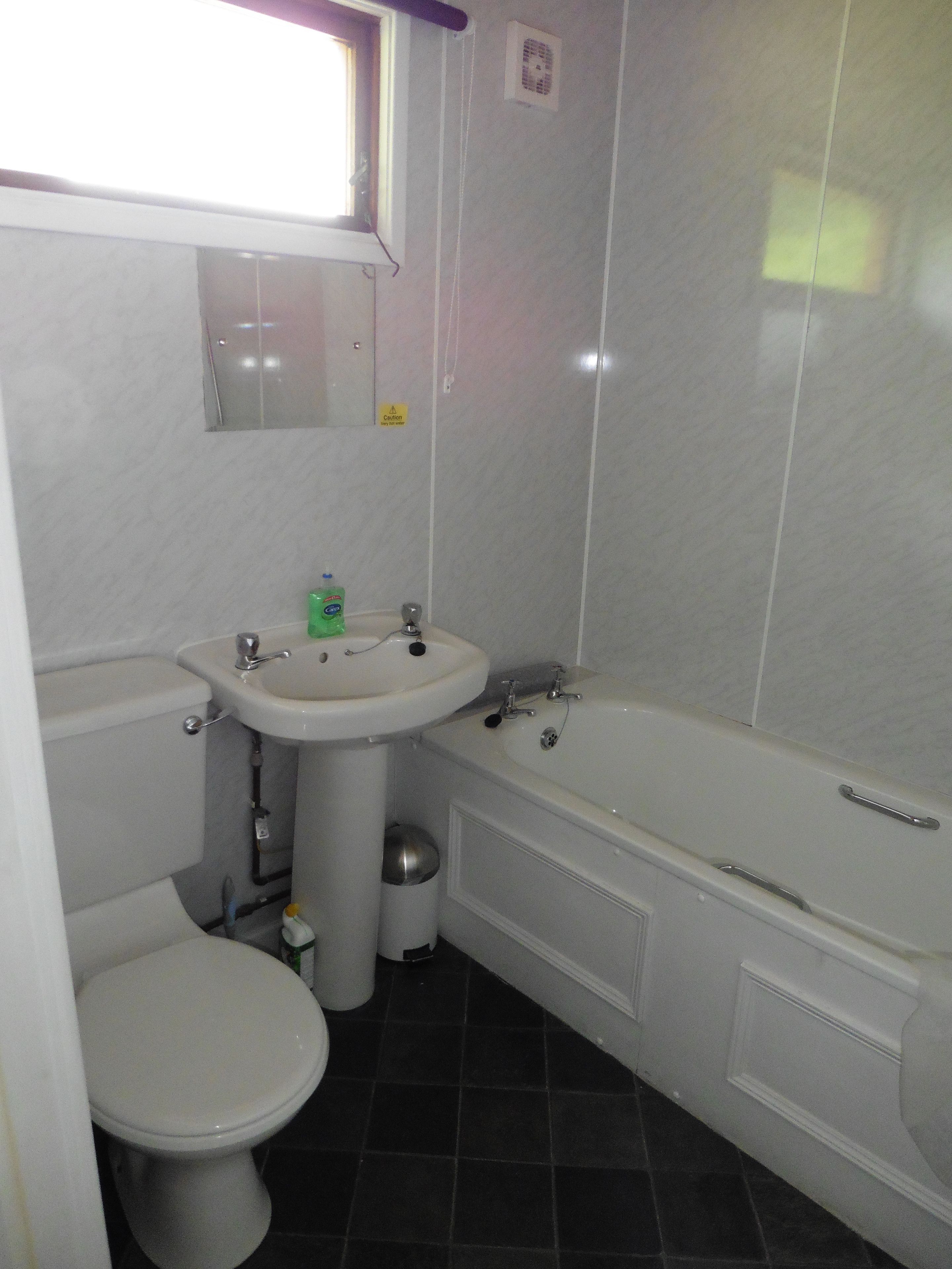 A bathroom with a toilet, sink, and bathtub.