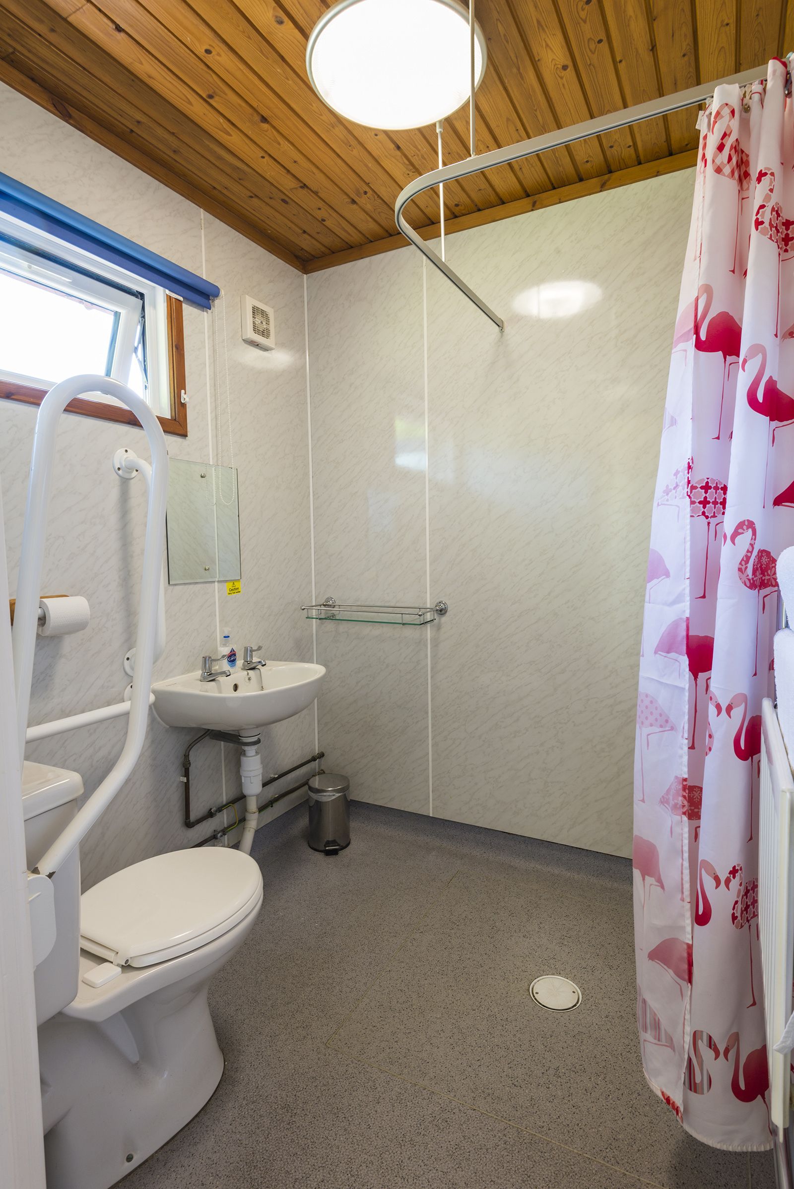 A bathroom with a toilet, sink, and shower.