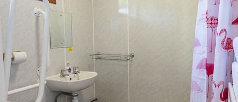 A bathroom with a toilet, sink, and shower.