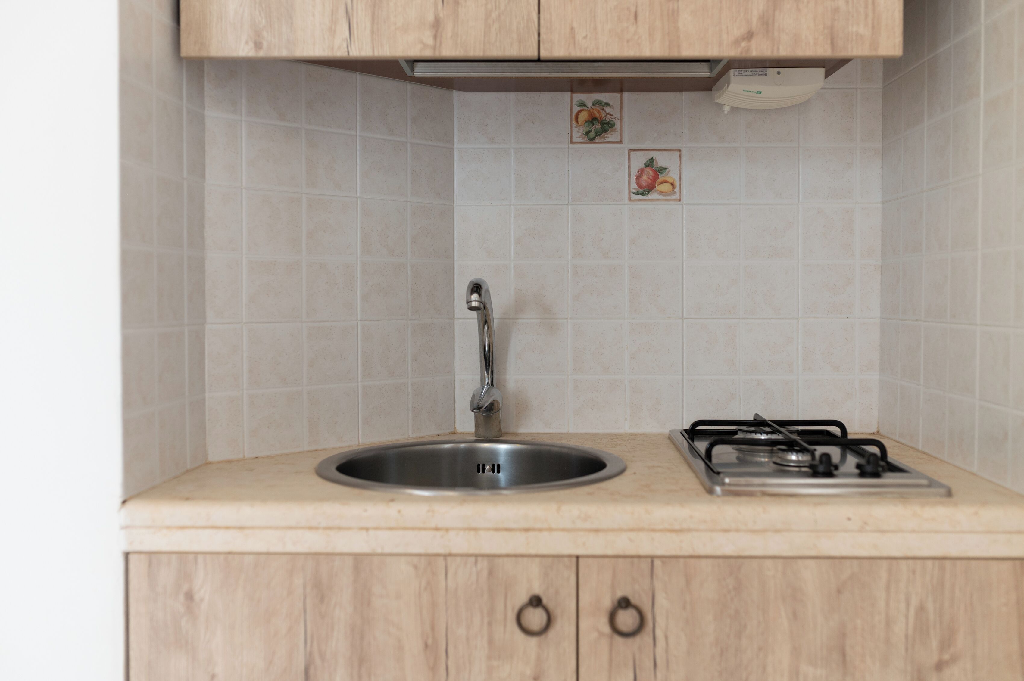 A kitchen with a sink, faucet, and stove.