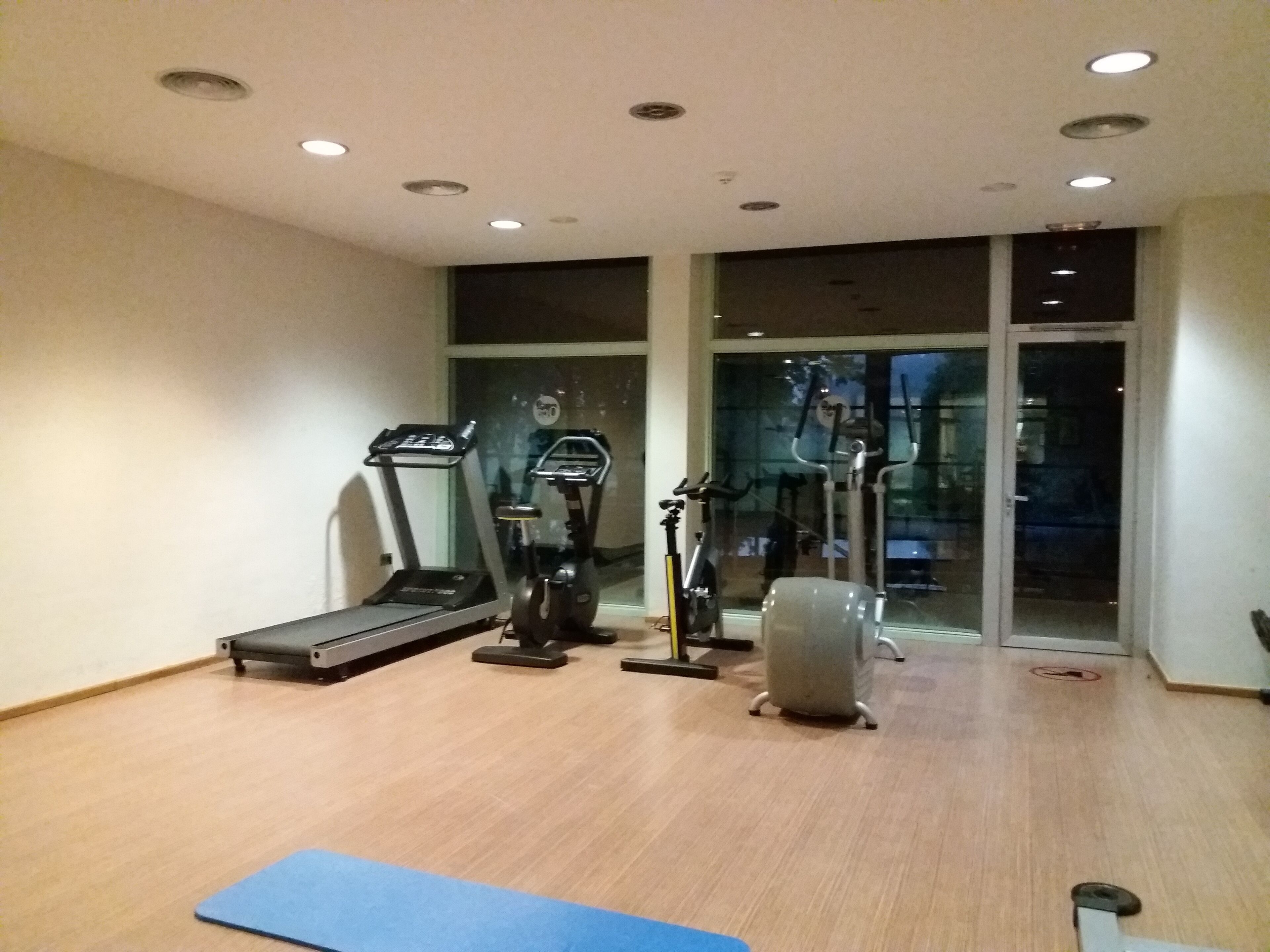 A gym with a treadmill, elliptical, and stationary bike.