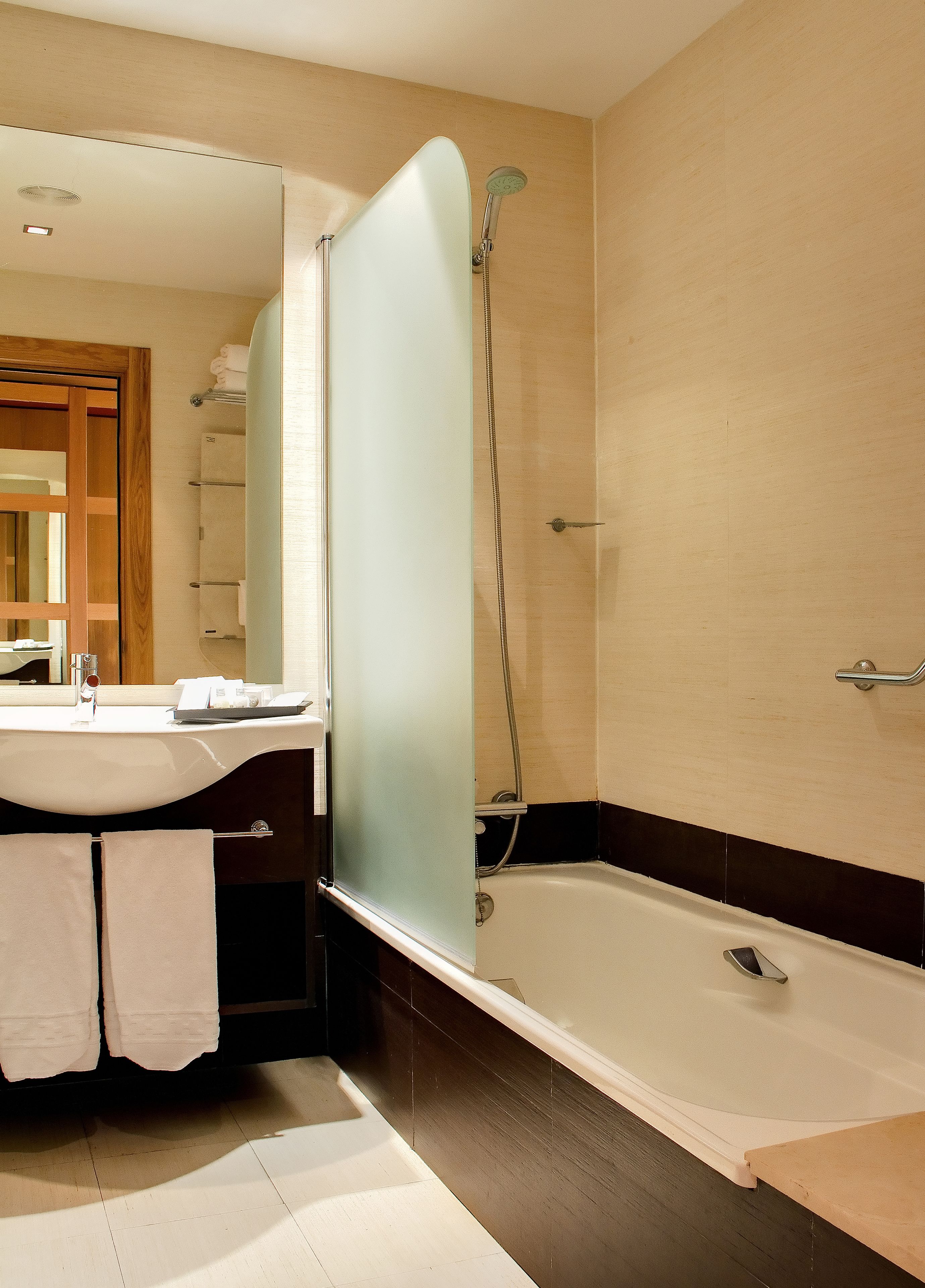 Ein Badezimmer mit Badewanne, Dusche, Waschbecken und Spiegel.