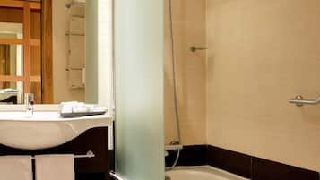 A bathroom with a bathtub, a shower, a sink, and a mirror.