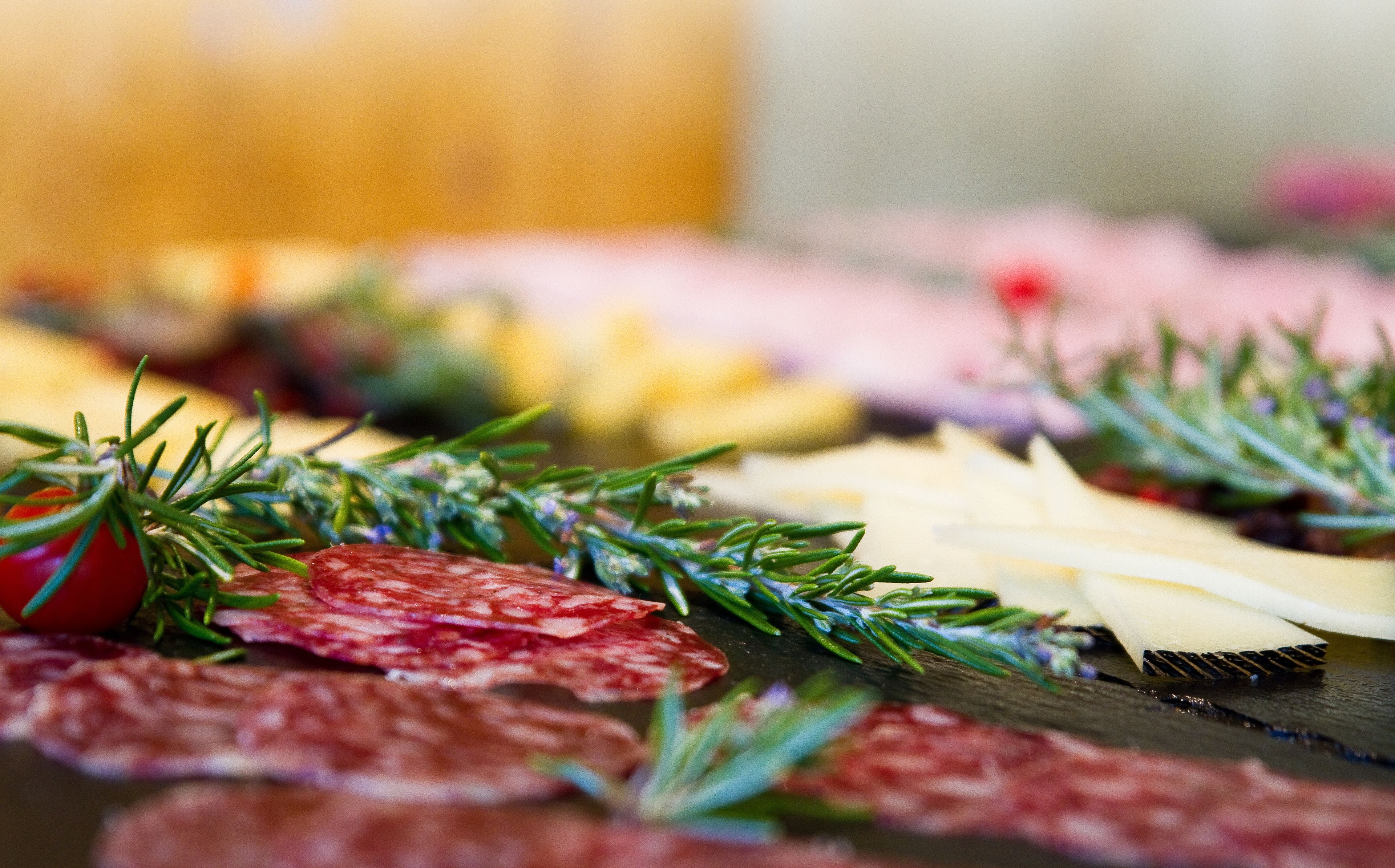 Eine Platte mit verschiedenen Wurstwaren, Käsesorten und Beilagen.