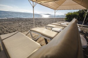 A beachside lounge with sun loungers under a canopy, overlooking the sea. - Katrancı Park Hotel (Fethiye)