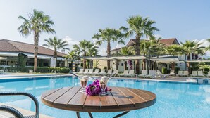 Ein Poolbereich mit Liegestühlen und einem Tisch mit Getränken.