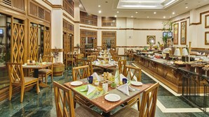 A spacious dining area with multiple tables and chairs, a buffet counter, and traditional wooden decor. - The Ummed Ahmedabad Airport (Ahmedabad)