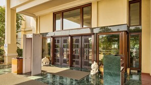 A hotel entrance with a double door, a reception desk, and a statue. - The Ummed Ahmedabad Airport (Ahmedabad)