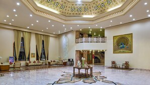 A spacious lobby with a high ceiling, ornate floral ceiling design, and a large mural. - The Ummed Jodhpur Palace Resort & Spa (Jodhpur)