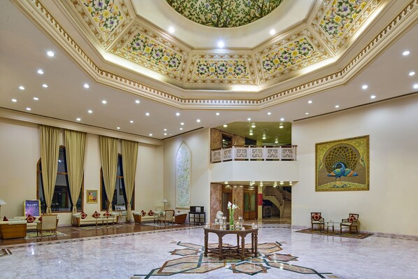A spacious lobby with a high ceiling, ornate floral ceiling design, and a large mural. - The Ummed Jodhpur Palace Resort & Spa (Jodhpur)