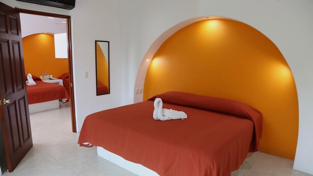 Een hotelkamer met een bed, een spiegel en een deur.