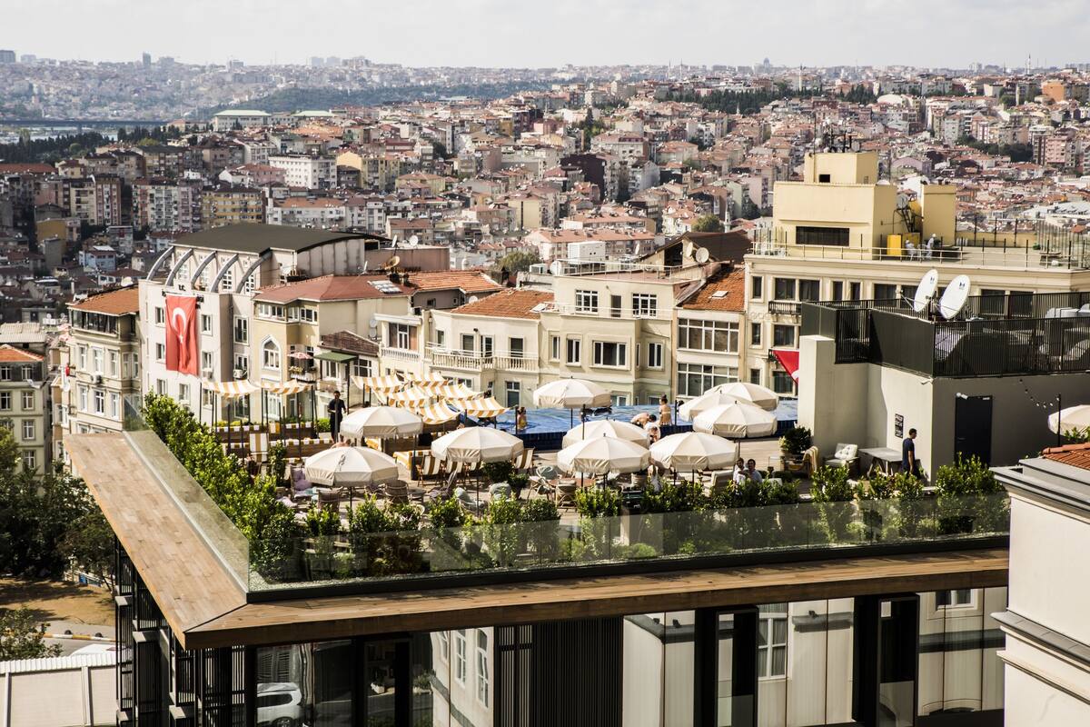 A rooftop terrace with outdoor seating and a view of a cityscape.