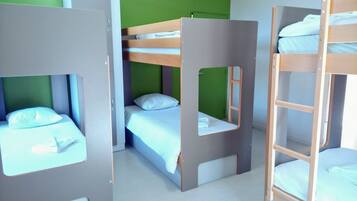 Habitación tipo dormitorio con literas y un separador.
