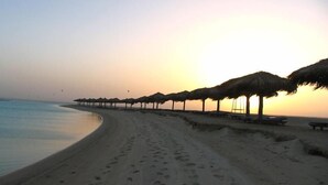 En la playa, camastros, sombrillas y toallas de playa 