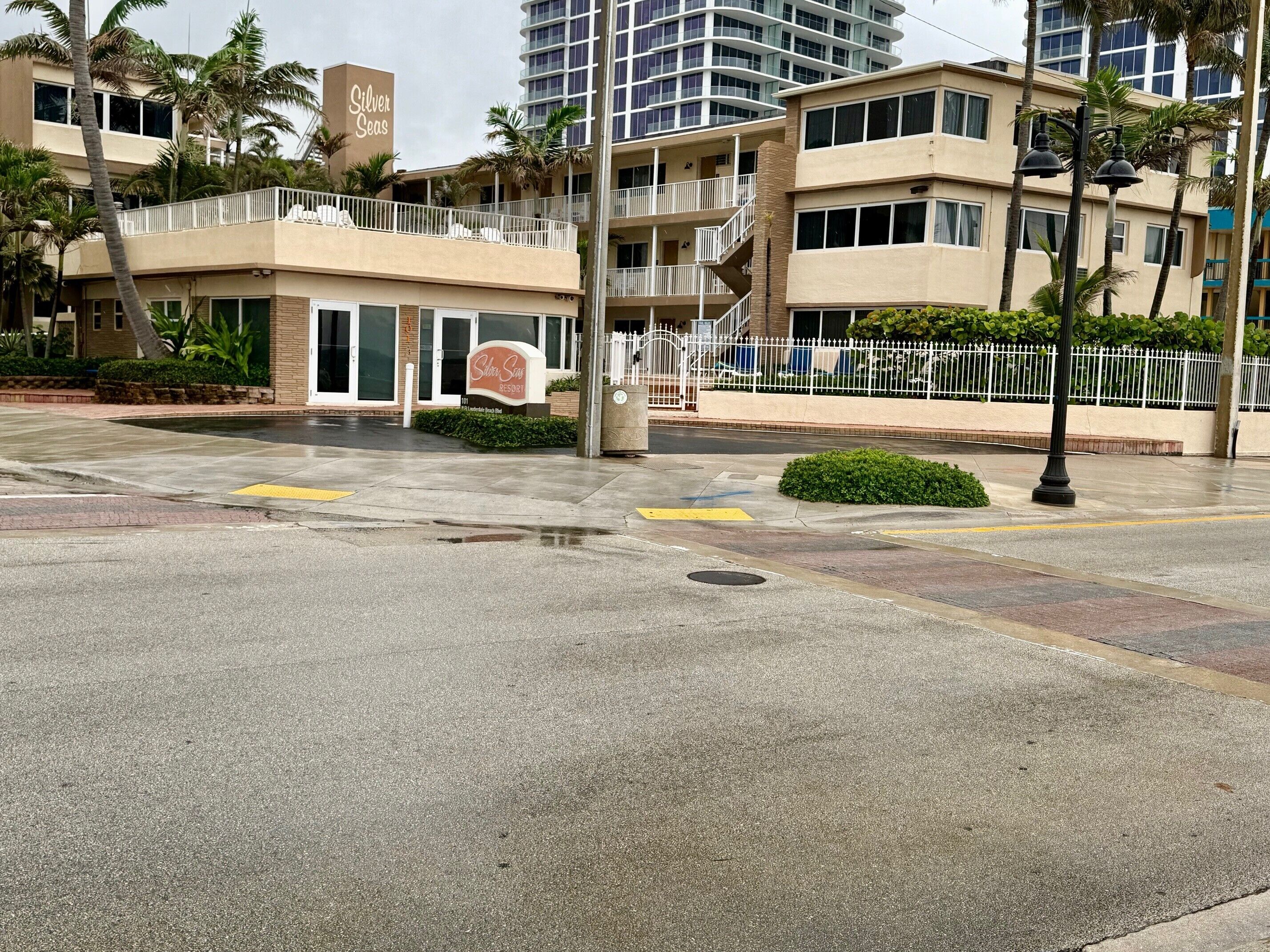 A hotel with a sign reading "Silver Seas" and a building with balconies and palm trees.