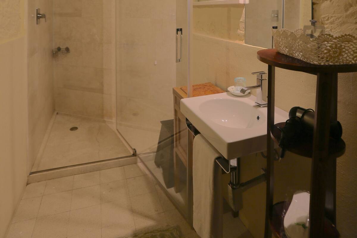 Ein Badezimmer mit Dusche, Waschbecken und Spiegel.