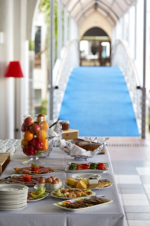 A buffet table with various dishes and a glass of fruit. - Hotel Slipway (Dar es Salaam)