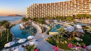 A hotel with multiple balconies, a swimming pool, and a beach view. - Grand Velas Los Cabos - All Inclusive (Cabo San Lucas)