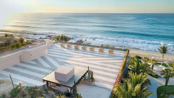 A resort with a pool area, a cactus garden, and a view of the ocean.