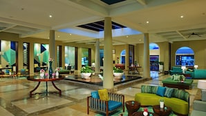 A spacious lobby with a central fountain, multiple seating areas, and large windows offering views of the cityscape. - Dreams Dominicus La Romana - All Inclusive (San Rafael del Yuma)