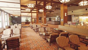 A spacious lobby with rows of seating, a reception area, and a food counter. - Watarase Onsen Hotel Sasayuri (Tanabe)