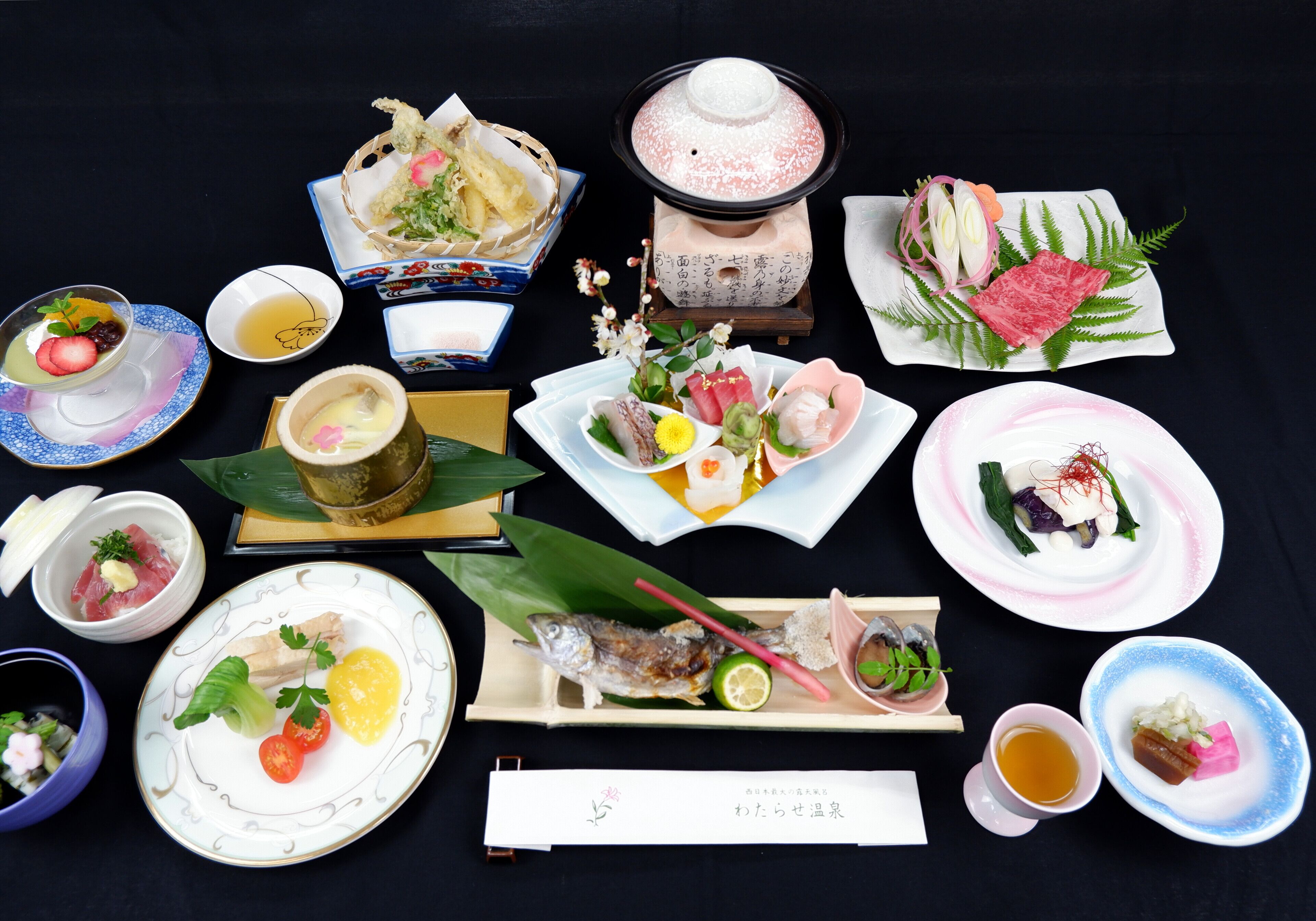Ett urval av japanska rätter och drycker som är upplagda på ett bord.