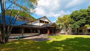 A modern house with a large glass facade, a covered porch, and a well-maintained lawn. - Watarase Onsen Hotel Sasayuri (Tanabe)