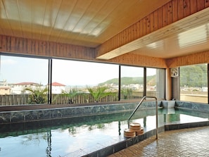 Un área de spa con piscina, techo de madera y vistas a la ciudad.