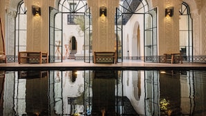 A pool with ornate arches and a reflection of the architecture. - Riad Kheirredine (Marrakech)