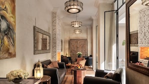 A spacious living area with a modern sofa set, a coffee table with fruit, and a decorative lantern. - Riad Kheirredine (Marrakech)