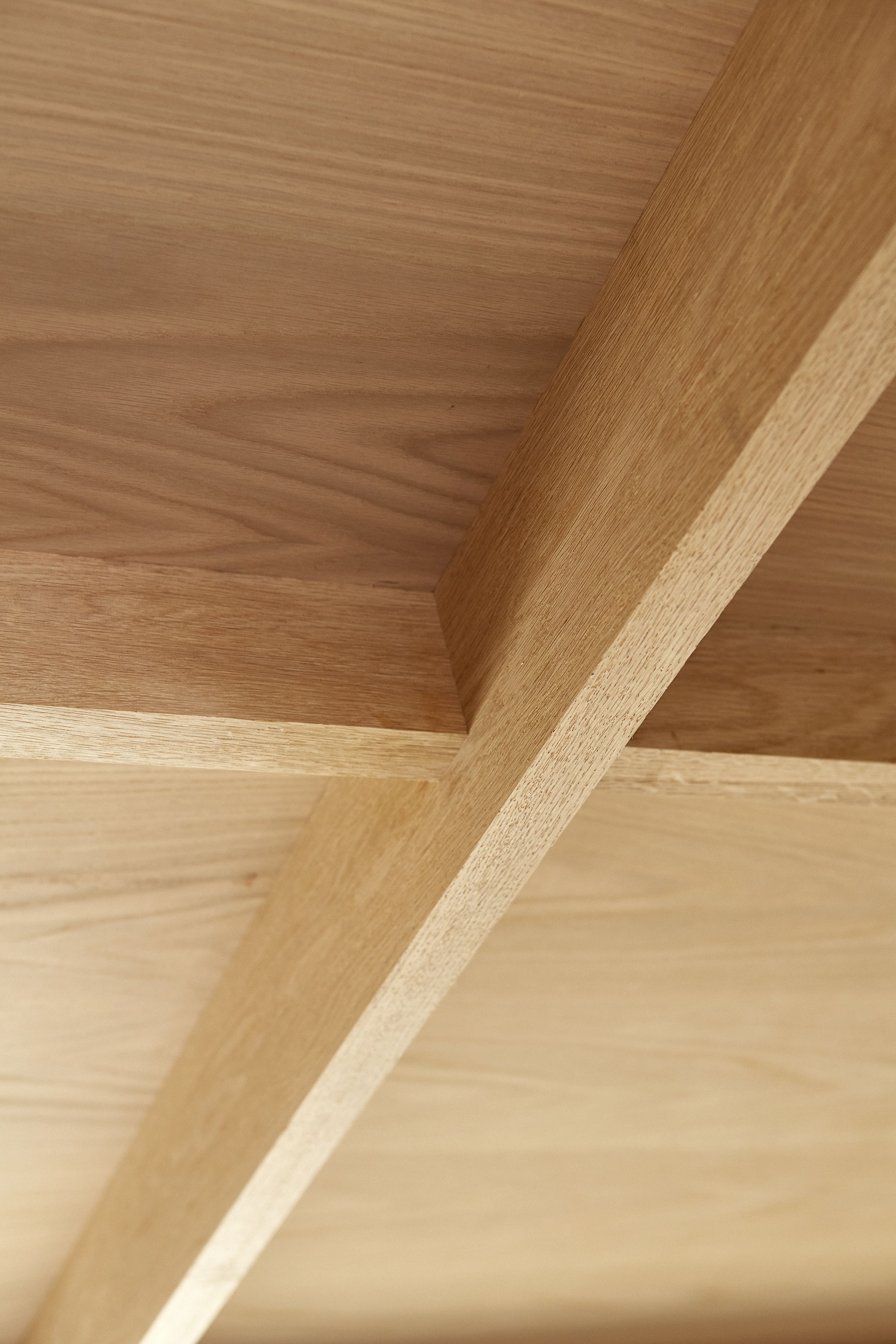 A close-up of a wooden ceiling structure with intersecting beams.
