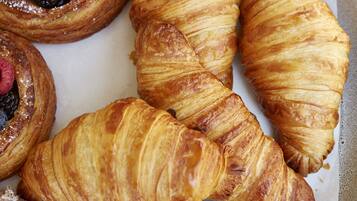 A tray of pastries including croissants and berry-filled pastries.