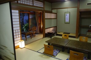 A traditional Japanese room with tatami flooring, a low table, and wooden furniture. - Kobayashiya (Toyooka)