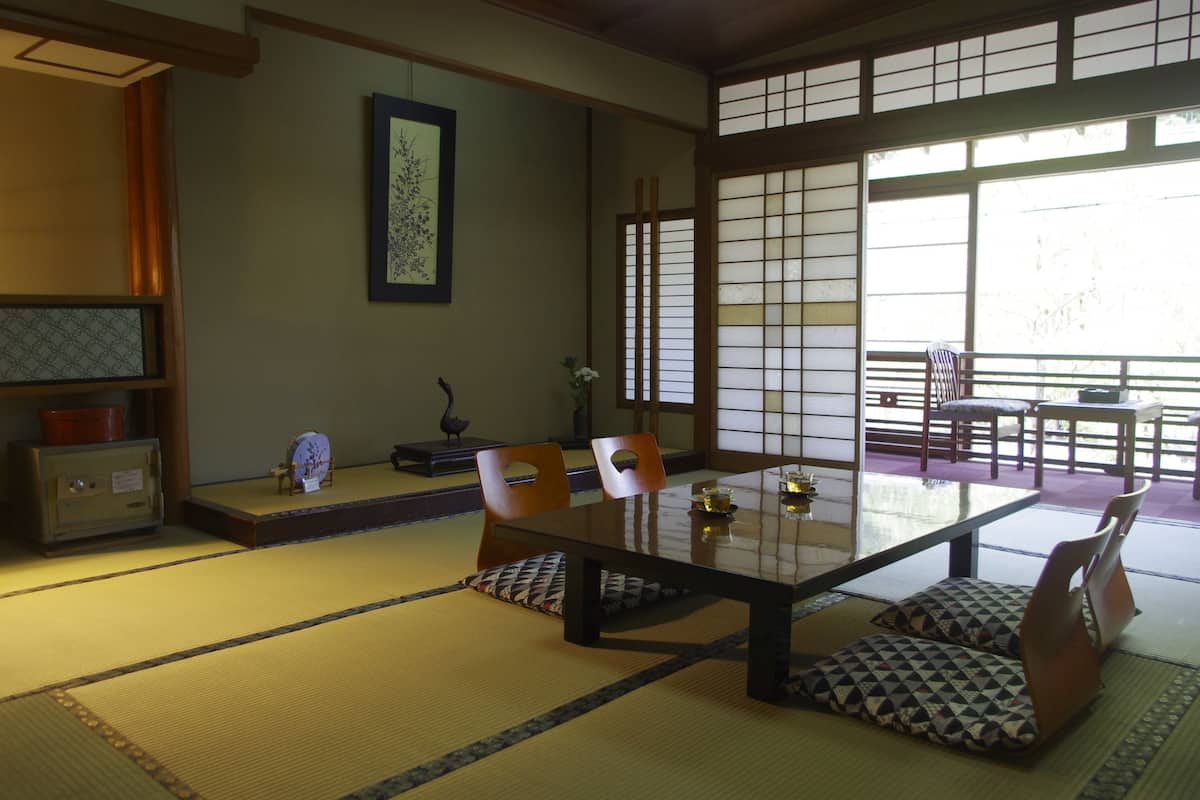 A traditional Japanese room with tatami flooring, a low table, and shoji screens.