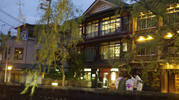 Un edificio japonés tradicional con varios pisos, ventanas grandes y un balcón.
