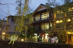 Un edificio japonés tradicional con varios pisos, ventanas grandes y un balcón.
