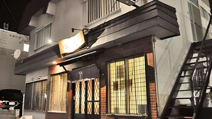 A building with a large sign, a staircase, and a barred window. - New Chiko Hotel (Hokkaido)